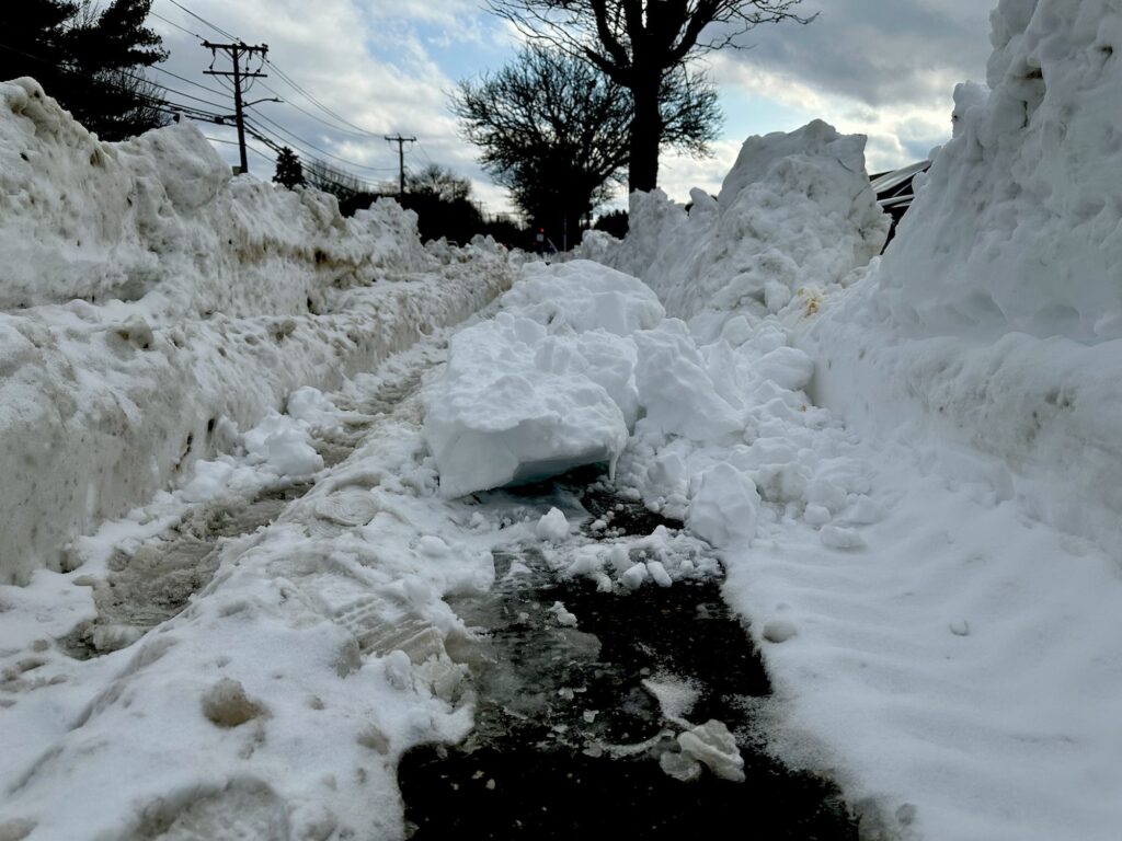 Sidewalk is partially plowed, but with major impediments.