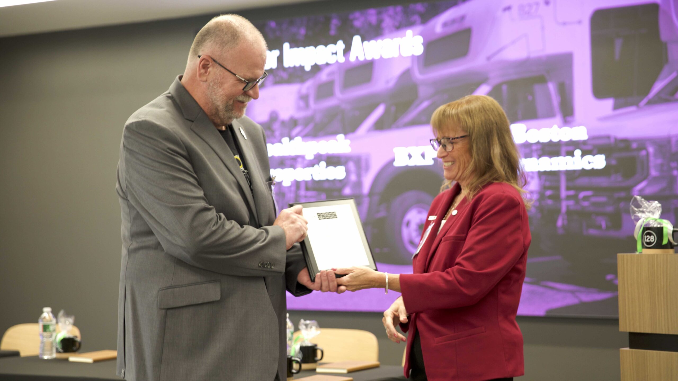 Boston Dynamics Director of Facilities Danny McInnis accepts the Member Engagement Award from 128BC Executive Director Lisa Stiglich.